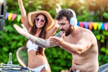 DJ havuz partisinde müzik çalıyor. İnsanlar, müzik, mutluluk ve eğlence konsepti.