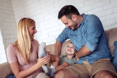 Aile evde boş zaman geçiriyor. Neşeli aile oğullarıyla yatakta eğleniyor..
