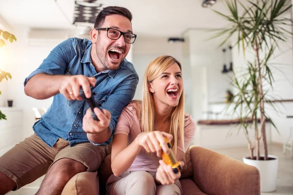 Cheerful boyfriend and girlfriend playing video games to win. Happy couple  using controller to play online game and winning gameplay on console.  People holding joystick to have fun Stock Photo - Alamy