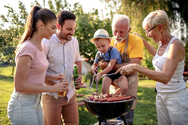 ピクニックでグリルの周りに幸せな大きな家族が集まりました レジャー 食べ物 家族や休日の概念 — ストック写真