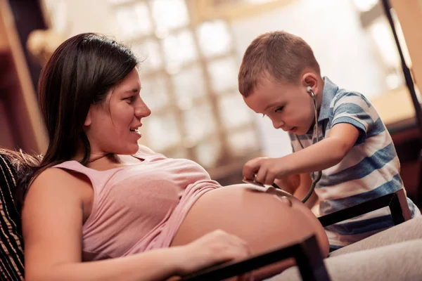 Menino Ouvindo Barriga Sua Mãe Grávida Através Estetoscópio — Fotografia de Stock