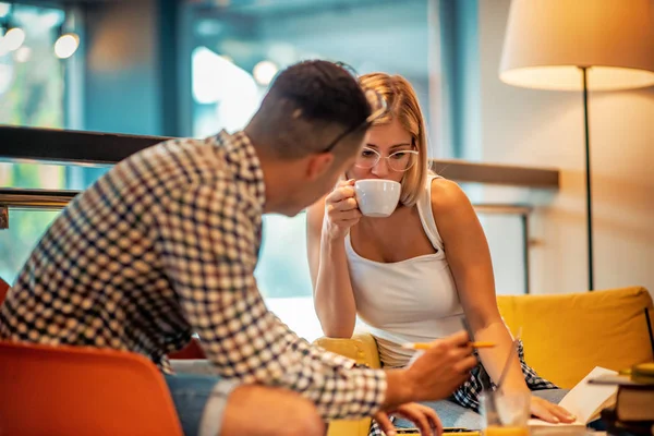 Junge Studenten mit einem Buch in der Bibliothek — Stockfoto