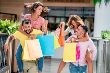 Alışveriş. Mutlu arkadaşlar alışveriş yaptıktan sonra kızları sırtlarında taşırlar. Turistler ve kızlar birlikte eğlenirler..