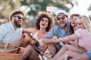 Yaz, tatiller, tatil ve mutluluk konsepti - akıllı telefonlu bir grup arkadaş selfie çekiyor.