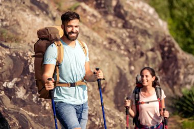Sırt çantalı ve yürüyüş sopalı yürüyüşçüler dağa tırmanıyor. Seyahat edin..