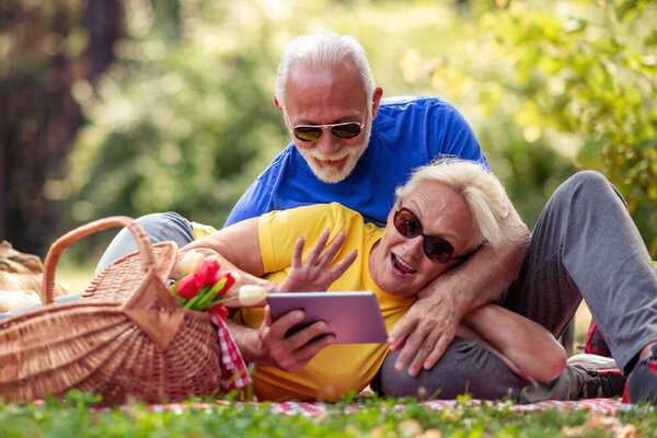Shot of a happy senior couple having a picnic in the park. 