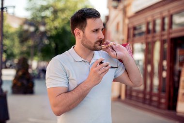 Alışverişe. Alışveriş merkezinde çantalı yakışıklı bir genç..