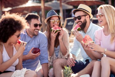 Arkadaşlar sahilde harika vakit geçiriyorlar, karpuz yiyorlar..