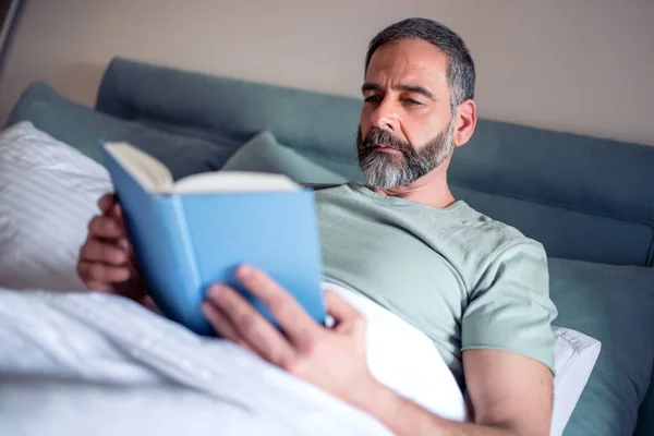 Зрелый Мужчина Лежит Спальне Читает Книгу — стоковое фото
