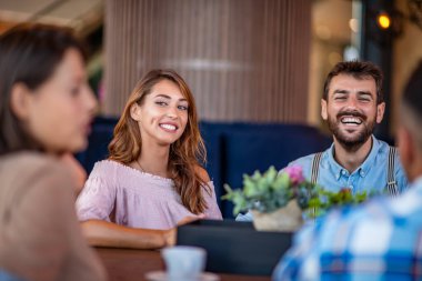 Kafe masasında oturan ve birlikte kahve içen gençler. Arkadaşlık ve yaşam tarzı kavramı.