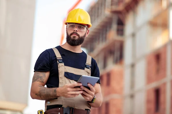 タブレットコンピュータを備えた建設現場の男性技術者 — ストック写真