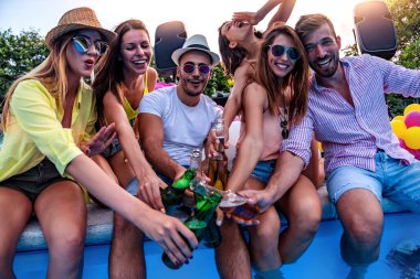 Arkadaşlarla havuz partisinin tadını çıkarıyorum. Bir grup arkadaş havuz kenarında parti veriyorlar..