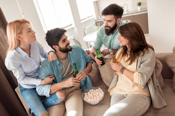 Happy friends watching soccer on tv and celebrating victory at home.Friendship, sports and entertainment concept.