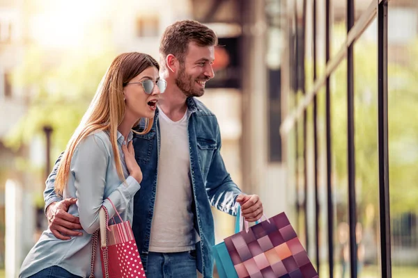 Glada Vackra Unga Par Som Håller Shoppingväskor Tittar Skyltfönster Och — Stockfoto