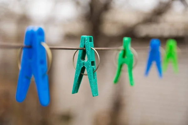 Multicolored clothespins hang on a wire