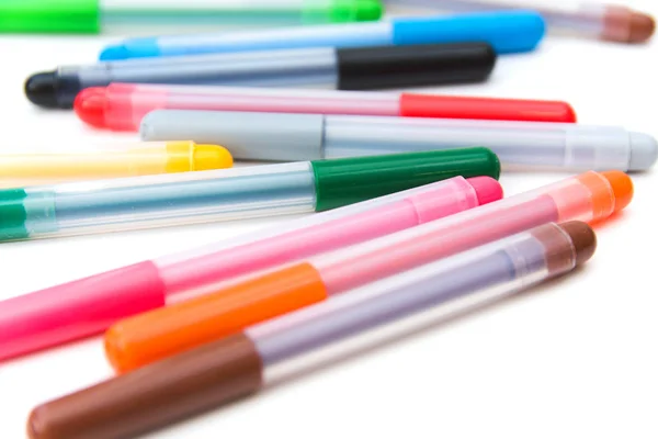 Colorful markers scattered on a white background. Art and education.  Selective focus.