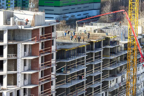 SAINT-PETERSBURG, RUSSIA - APRIL 9, 2020: Construction of a residential multi-storey building made of monolithic reinforced concrete. Builders fill the floor slab with concrete, fed by a concrete pump — Stock Image Saint Petersburg Russia April 2020 Construction Residential Multi Storey Building Stock Picture