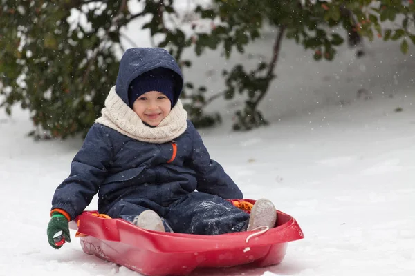 Felice bambino sulla sua slitta nella neve invernale — Foto Stock