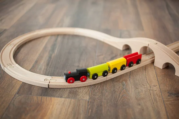 Tren de juguete de madera en ferrocarril con puente de madera. Suelo laminado limpio — Foto de Stock