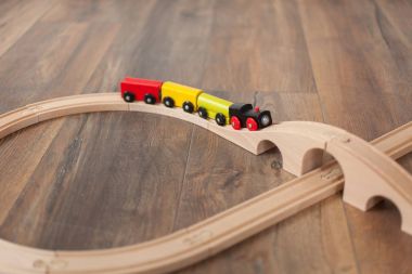 Tahta köprüsü olan tahta bir oyuncak tren. Temiz kaplamalı zemin