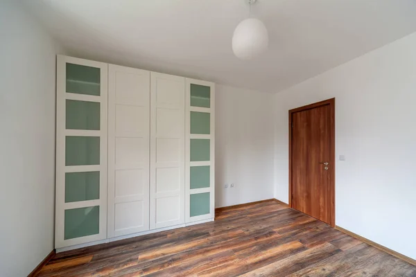 Bela casa moderna, sala vazia com roupeiro branco (armário), piso de madeira — Fotografia de Stock