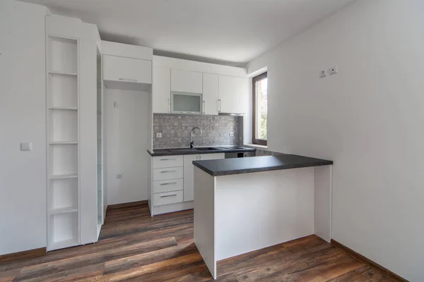 Nieuwe moderne en lege witte keuken. Nieuw huis. Interieurfotografie. Houten vloer. — Stockfoto