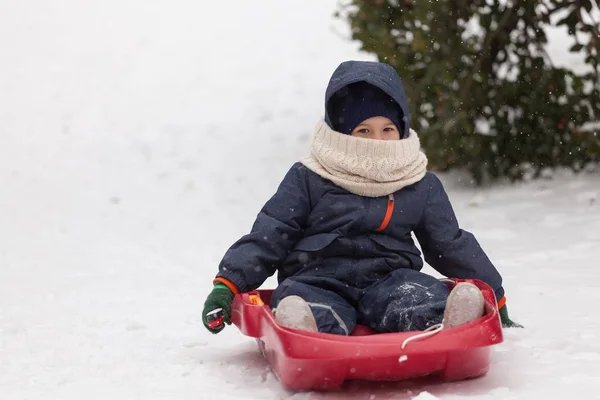 Little boy on his sled in winter snow — Stock Photo, Image