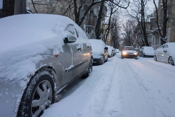 Calle urbana después de tormenta de nieve. Coches cubiertos de nieve — Foto de Stock