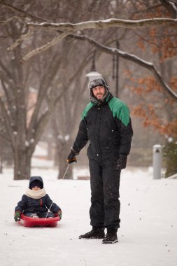 Babası bir çocuk bir kızağa çeker. Baba ve oğul kış zamanda halletme.