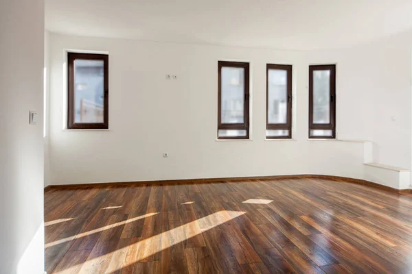 Leerer Raum mit Tageslicht aus Fenstern. Modernes Haus-Interieur. Weiße Wände. Holzboden. — Stockfoto