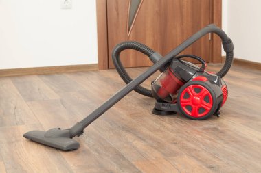 Elektrikli süpürge ahşap zemin üzerinde. Ev Temizleme