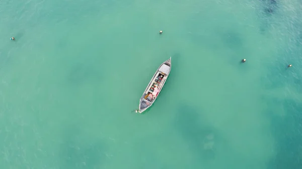 Одинокая рыбацкая лодка в бирюзовом океане, море. Фото с воздуха, вид сверху — стоковое фото