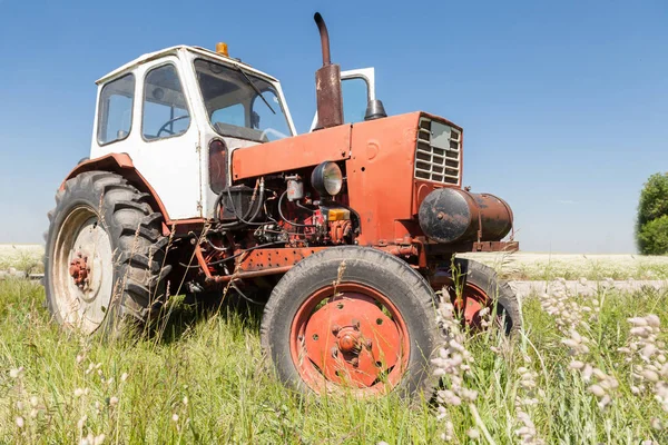 Old red tractor on the field. — Stock Photo, Image