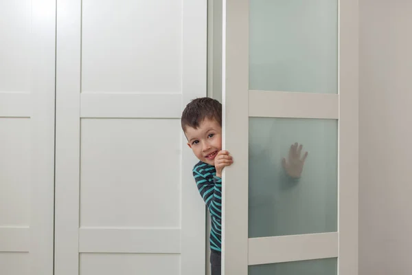 在家衣柜里可爱的小男孩。偷看, 躲藏, 玩耍 — 图库照片