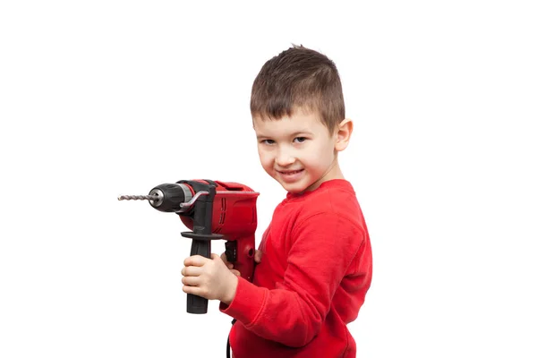 Retrato de um rapazinho feliz a segurar uma broca eléctrica. Um pequeno trabalhador da construção. Isolado em branco — Fotografia de Stock