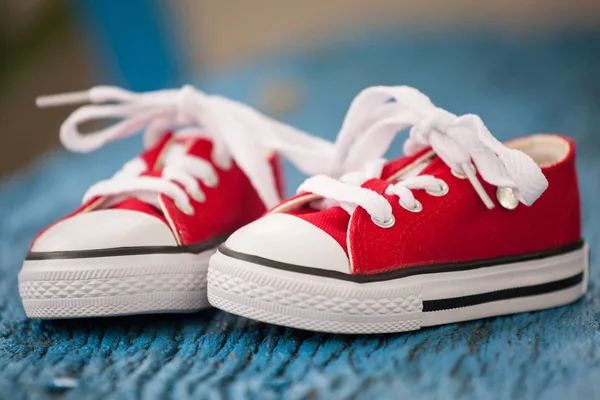 Rote Baby Turnschuhe auf blauem Hintergrund — Stockfoto