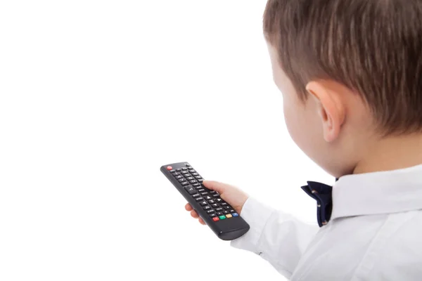 Kleiner Junge, der per Fernbedienung die Kanäle im Fernseher wechselt, isoliert auf weiß. Leere Räume — Stockfoto