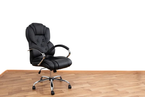 Czarny skórzany fotel w pokoju, drewniana podłoga, białe ściany. Wnętrze biznesu — Zdjęcie stockowe