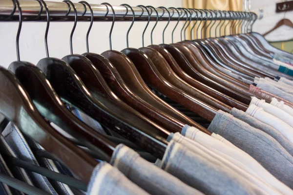 Line of clothes on wooden hangers in store. Sale — Stock Photo, Image