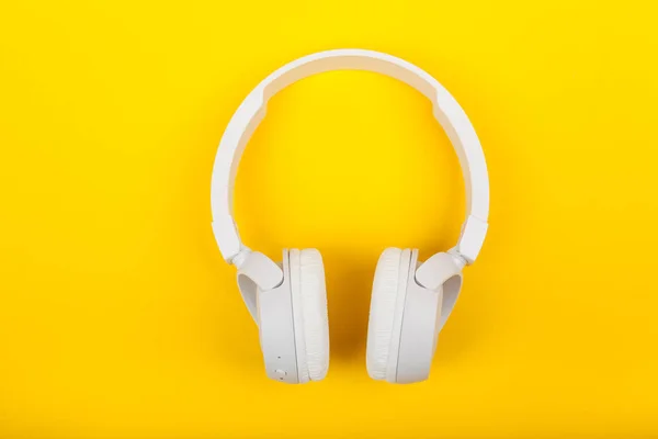 Auriculares blancos inalámbricos sobre fondo amarillo. Concepto musical. Auriculares sobre fondo amarillo . —  Fotos de Stock