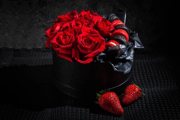 赤いバラとマカロン、イチゴで飾られたプレゼントボックス。バレンタインデーと女性デーの背景。結婚式の装飾 — ストック写真