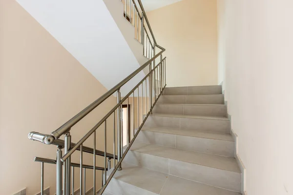 Современная лестница между этажами. Лестницы с металлическими рельсами в современном здании — стоковое фото
