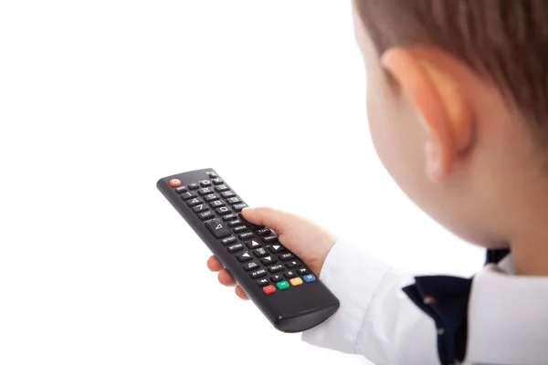 Kleiner Junge, der per Fernbedienung die Kanäle im Fernseher wechselt, isoliert auf weiß. Leere Räume — Stockfoto