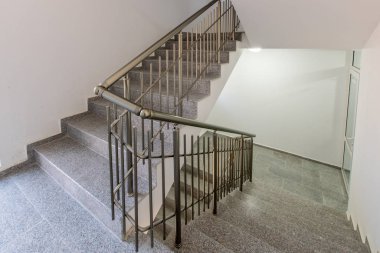 Katlar arasında modern merdiven. Modern binada metal raylı merdivenler