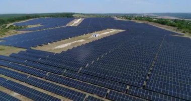 Fotostatik güneş çiftliğinin 4K hava görüntüsü. Güneş çiftliği elektrik santrali yukarıdan. Ekolojik yenilenebilir enerji.