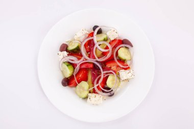 Peynirli salata ve beyaz tabakta taze sebze. Yunan salatası.