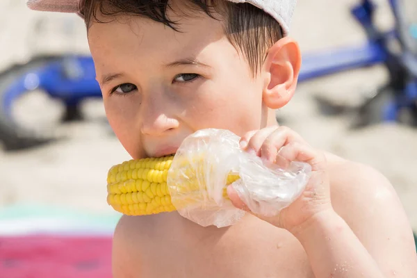 Mały Chłopiec Jedzący Gotowaną Kolbę Kukurydzy Plaży — Zdjęcie stockowe