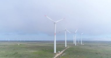 Sisteki yel değirmenlerinin 4K hava görüntüsü. Modern rüzgar türbinleri. Rüzgar en temiz, yenilenebilir enerji kaynağıdır.. 