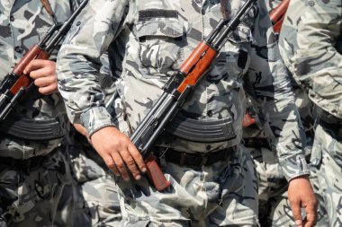 Kamuflaj üniformalı silahlı askerler. Askerlerin silahlarını kuşanın.