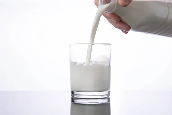 牛乳を瓶からグラスに入れる 白い背景 — ストック写真